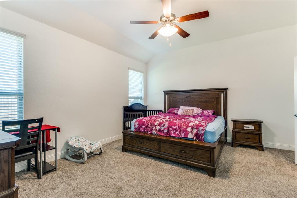 10312 Georgetown Place McKinney, TX 75071 - Photo 21 of 25 a bedroom with a bed and a chandelier