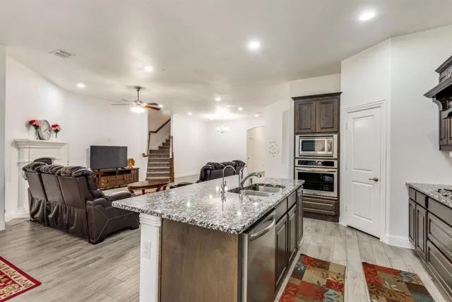 a kitchen with stainless steel appliances granite countertop a sink stove and refrigerator