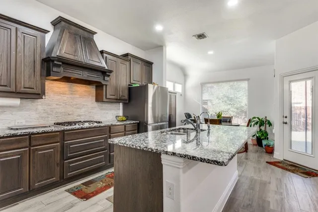 a kitchen with stainless steel appliances granite countertop a refrigerator stove and microwave