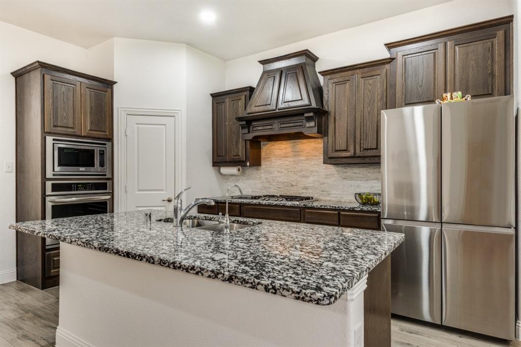 10312 Georgetown Place McKinney, TX 75071 - Photo 10 of 25 a kitchen with stainless steel appliances granite countertop a refrigerator stove and microwave