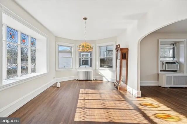 a view of empty room with wooden floor and windows