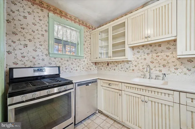 a kitchen with granite countertop white cabinets stainless steel appliances and sink