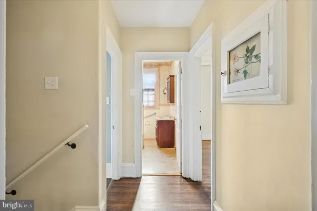 a view of a hallway with wooden floor and closet
