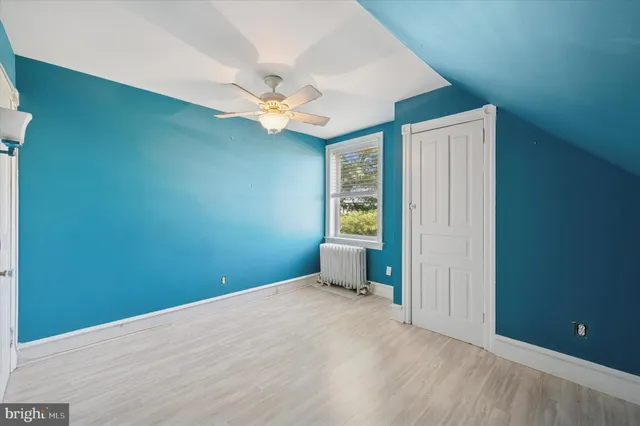 an empty room with closet and a ceiling fan
