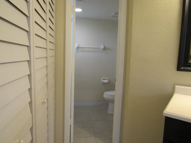 a bathroom with a granite countertop shower and a toilet