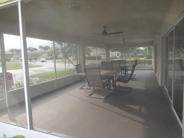 a dining room with furniture and a floor to ceiling window