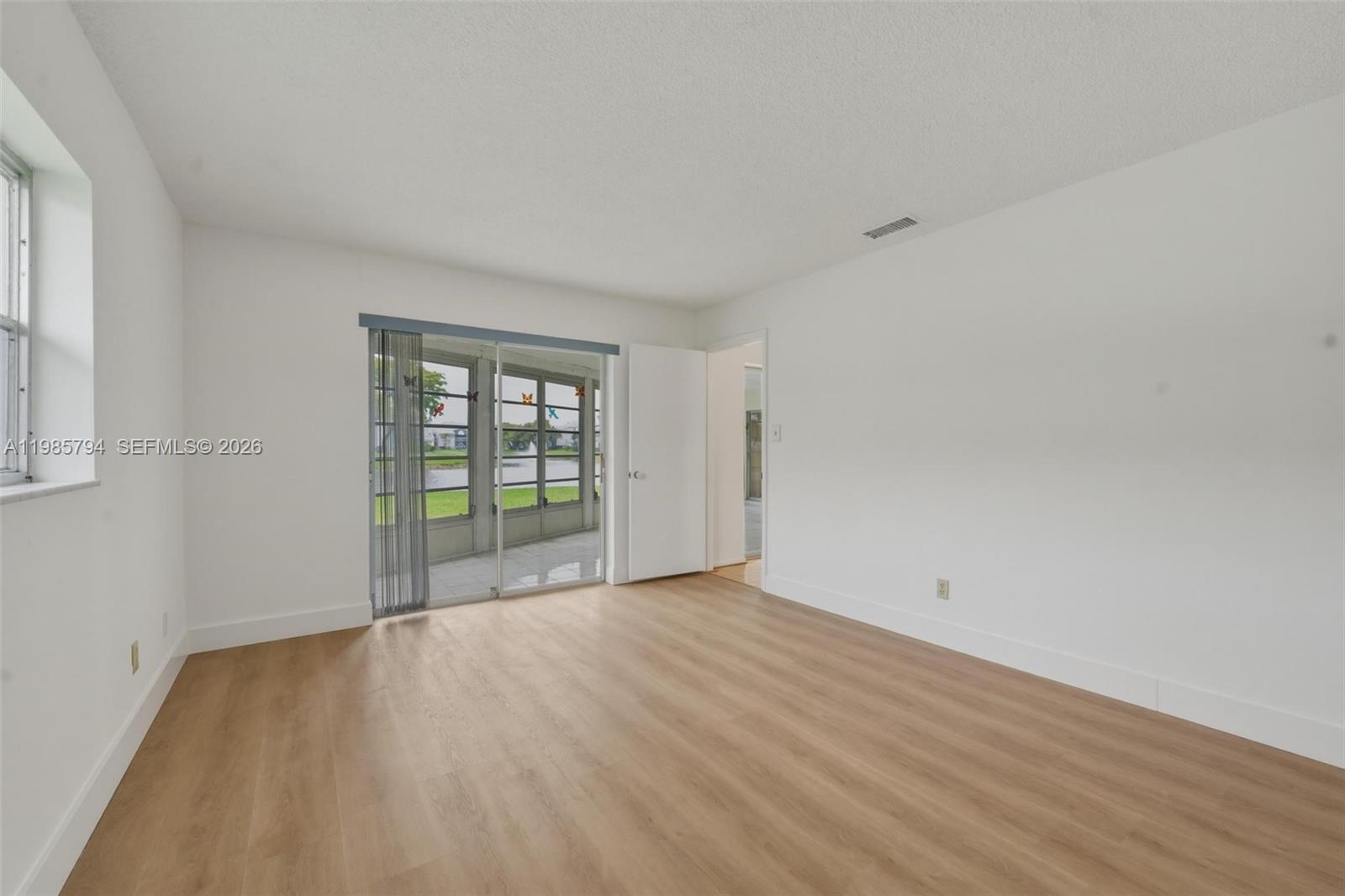9306 Northwest 80th Street Tamarac, FL 33321 - Photo 17 of 45 a view of an empty room with wooden floor and a window