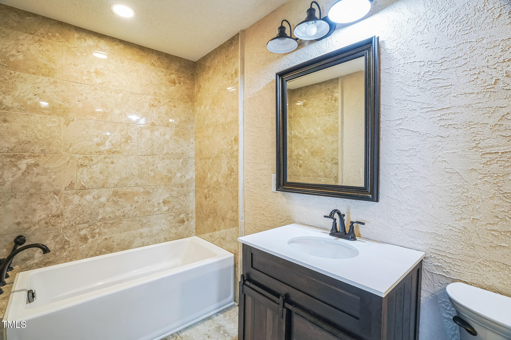 1270 Old School Road Four Oaks, NC 27524 - Photo 18 of 30 a bathroom with a sink a bathtub and a vanity