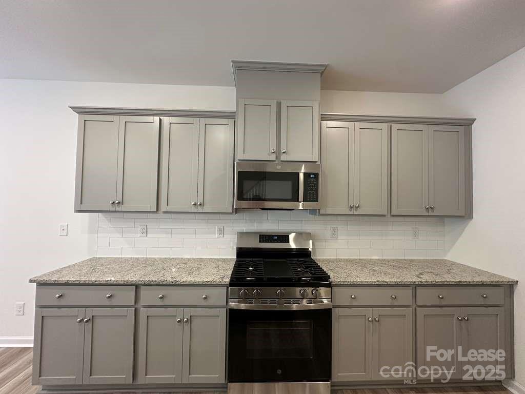 3514 Nimbell Road Monroe, NC 28110 - Photo 5 of 19 a kitchen with granite countertop white cabinets and black appliances
