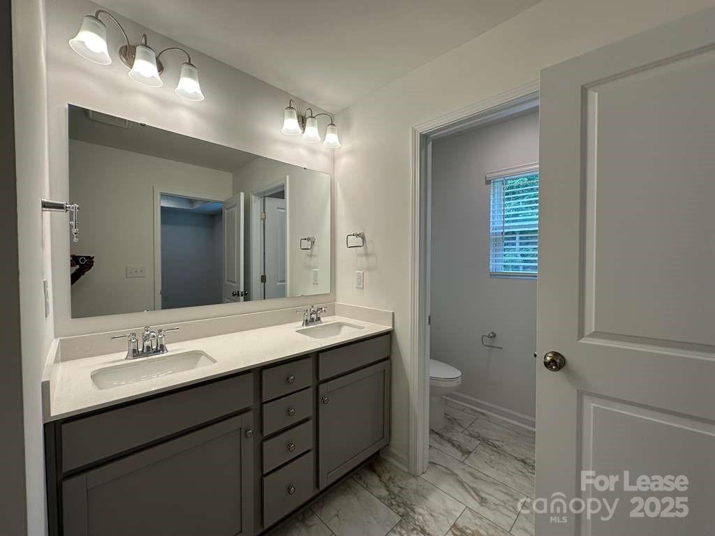 3514 Nimbell Road Monroe, NC 28110 - Photo 10 of 19 a bathroom with a double vanity sink toilet and a mirror