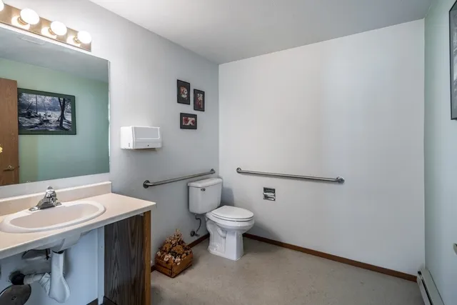 a bathroom with a sink mirror and toilet