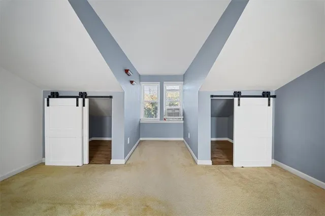 an empty room with closet and windows