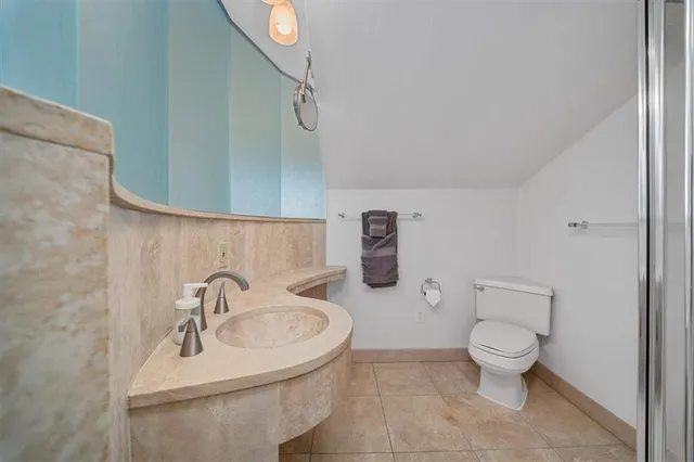 a bathroom with a toilet sink and mirror