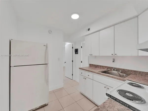 a kitchen with stainless steel appliances granite countertop white refrigerator stove and white cabinets