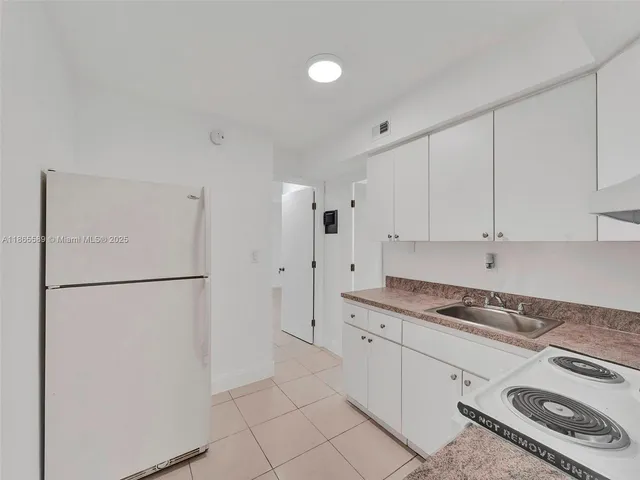 a kitchen with stainless steel appliances granite countertop white refrigerator stove and white cabinets
