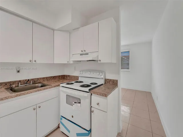 a kitchen with granite countertop white cabinets and white appliances