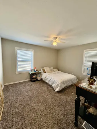 a spacious bedroom with a bed and a tv