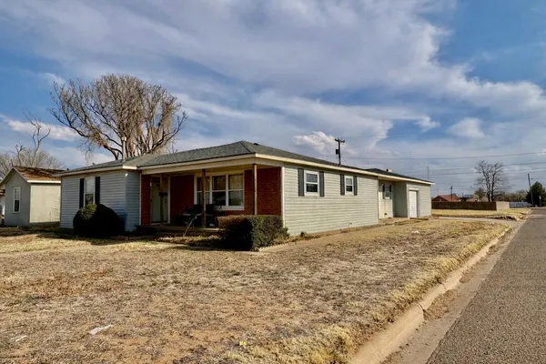 a front view of a house with a yard covered in snow