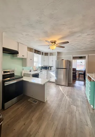 a kitchen with stainless steel appliances granite countertop a refrigerator and a stove top oven
