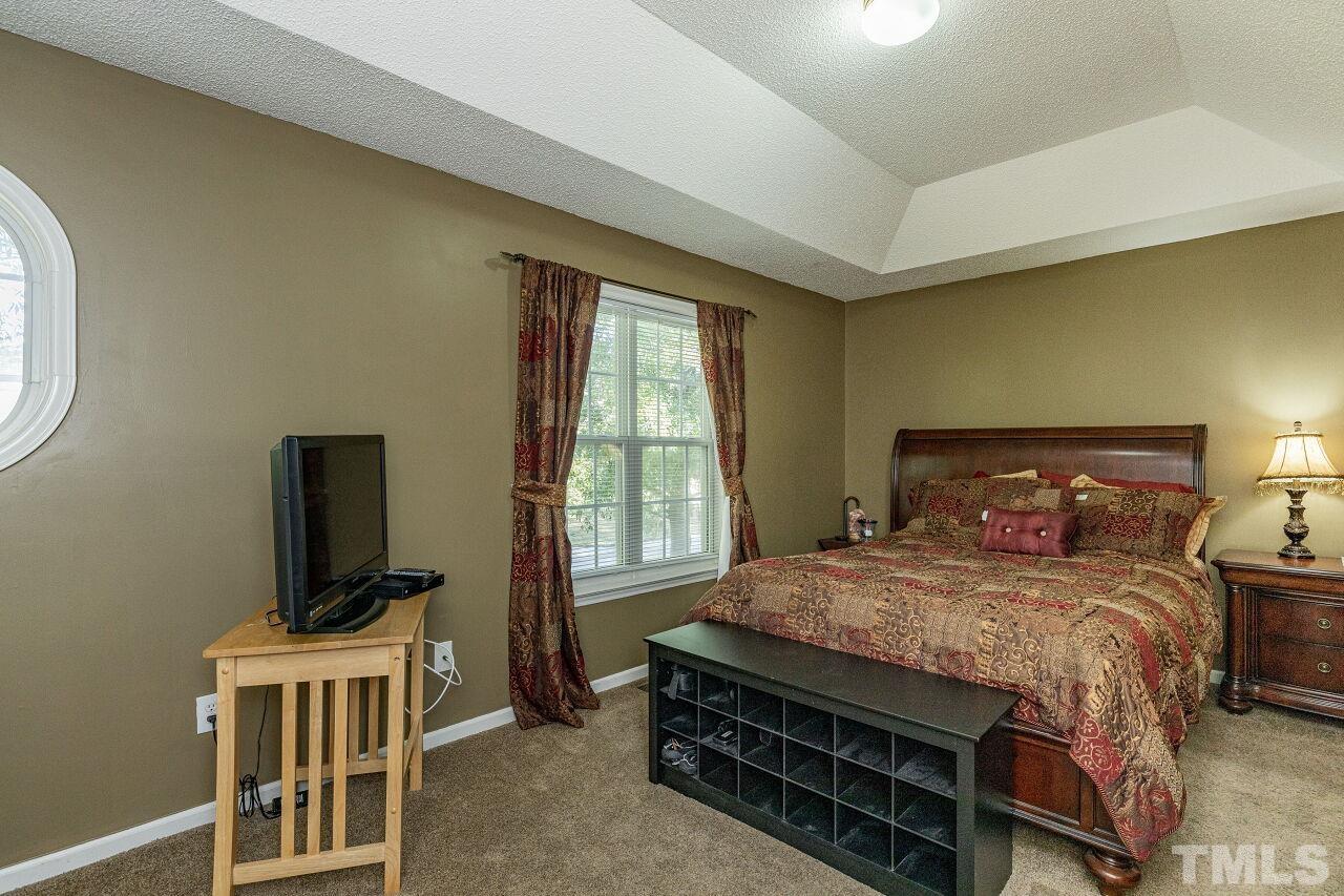 4420 Pottery Lane Raleigh, NC 27616 - Photo 14 of 29 a bedroom with a bed and a flat screen tv