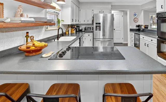 a kitchen with stainless steel appliances granite countertop a refrigerator and a stove