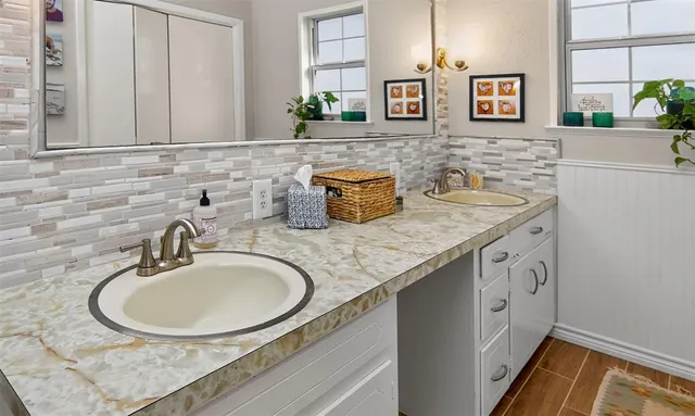 a bathroom with a granite countertop sink a mirror and vanity