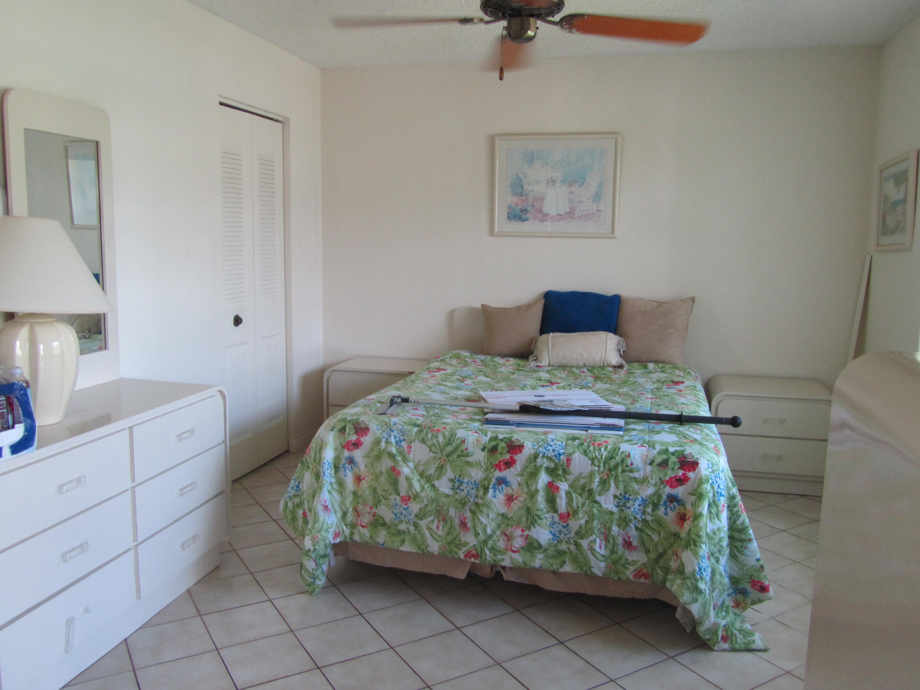 5368 Privet Place, Unit B Delray Beach, FL 33484 - Photo 7 of 15 a bedroom with a bed and a lamp on dresser