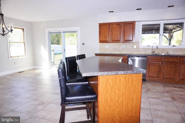 a living room with stainless steel appliances granite countertop furniture and a window