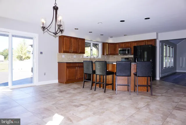 a view of kitchen with refrigerator cabinets and furniture