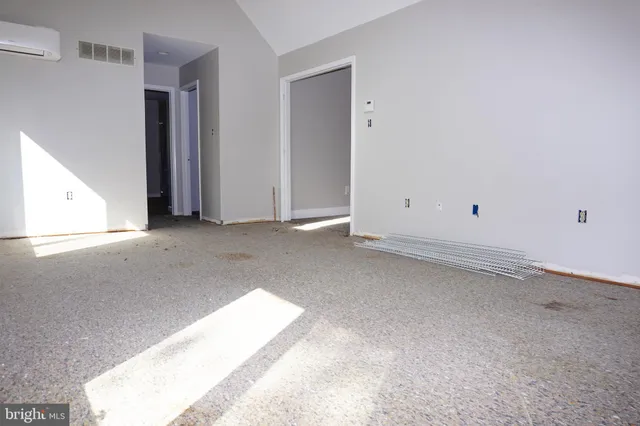 an empty room with a ceiling fan and windows