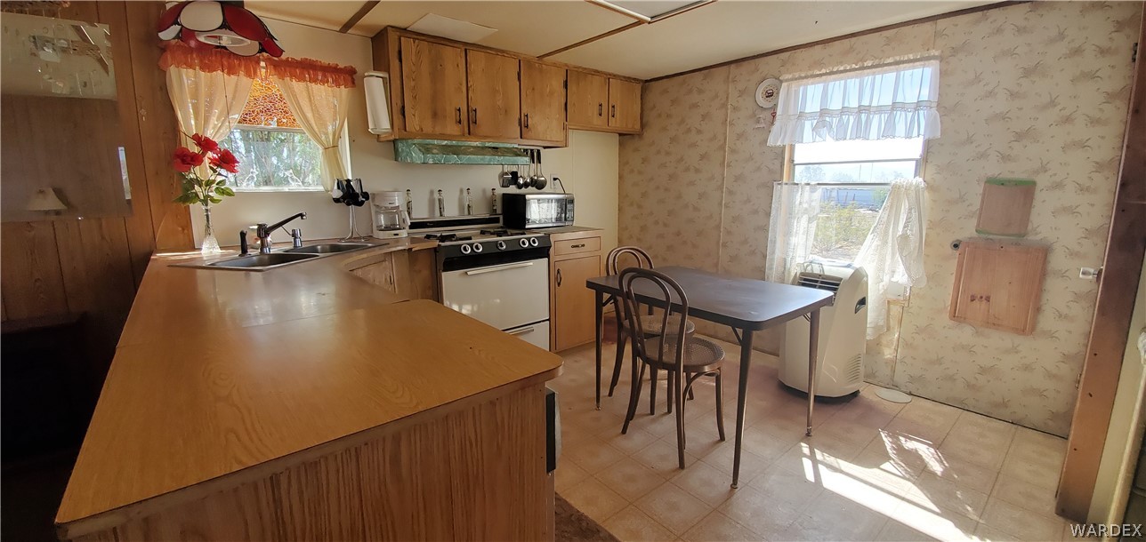 524 South Eden Road Golden Valley, AZ 86413 - Photo 19 of 32 a kitchen with sink a refrigerator and chairs