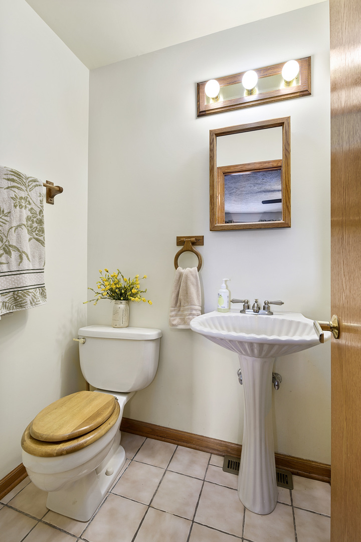 3205 Caton Farm Road Joliet, IL 60431 - Photo 11 of 20 a bathroom with a toilet a sink and mirror