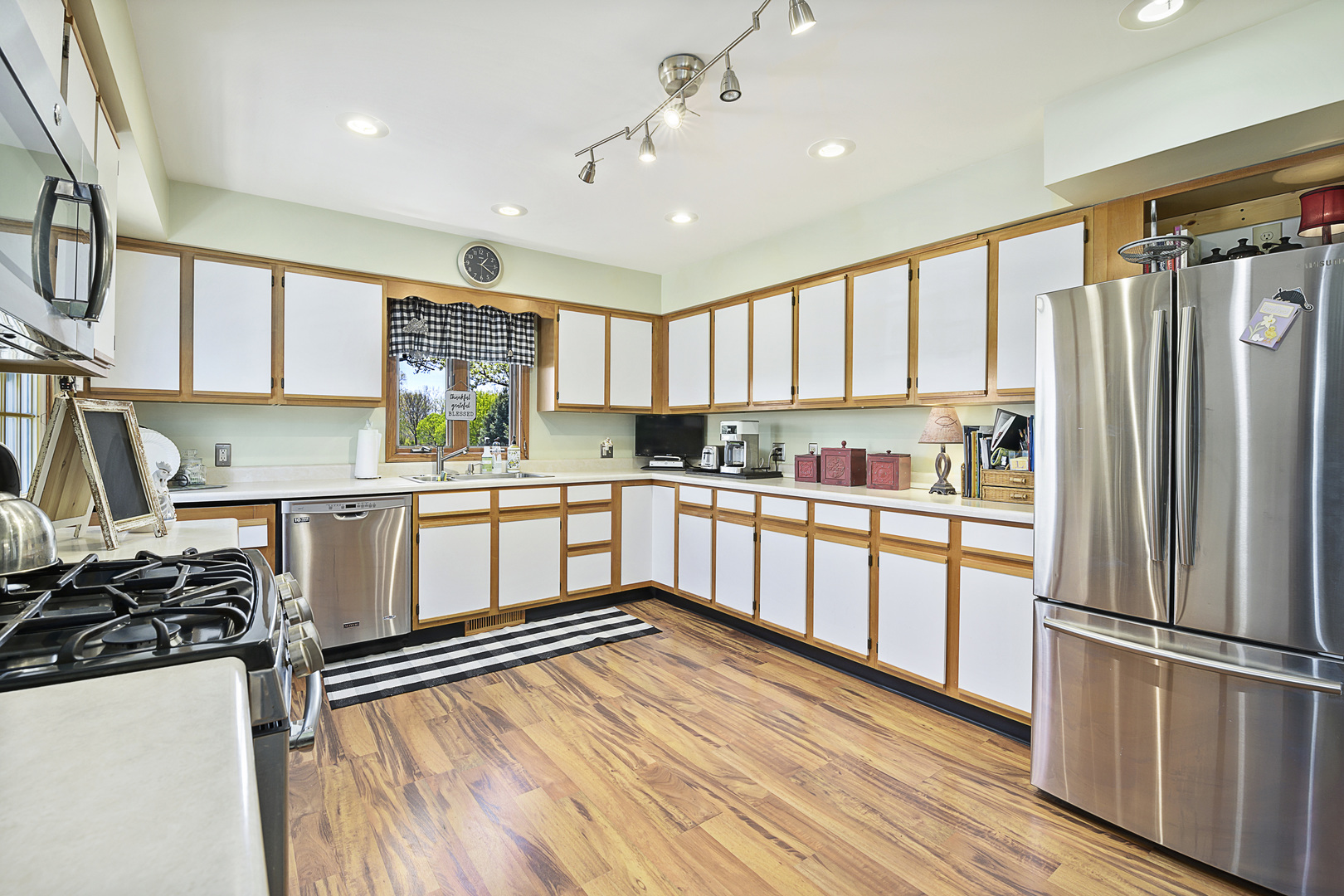 3205 Caton Farm Road Joliet, IL 60431 - Photo 16 of 20 a kitchen with stainless steel appliances granite countertop a refrigerator a sink dishwasher a stove and white countertops with wooden floor