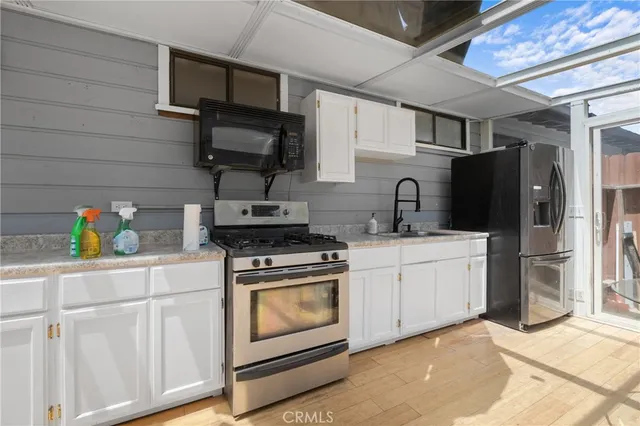a kitchen with stainless steel appliances granite countertop a refrigerator stove and sink