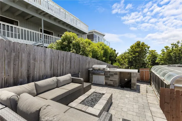 a backyard of a house with table and sofas