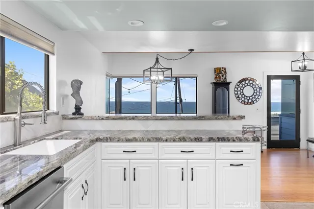 a view with granite countertop a sink and a wooden floor