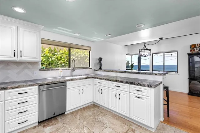 a kitchen with granite countertop a sink and cabinets