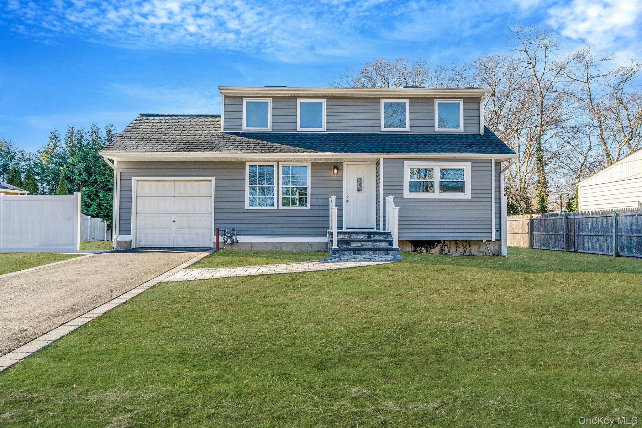 24 Clarkson Road Centereach, NY 11720 - Photo 1 of 1 Traditional-style house featuring asphalt driveway, roof with shingles, and an attached garage