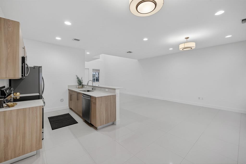737 Southeast 1st Court, Unit 737 Pompano Beach, FL 33060 - Photo 11 of 53 a kitchen with a sink and white cabinets