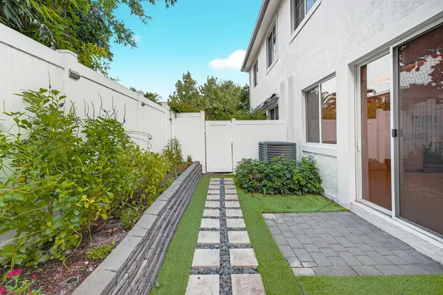 a view of an empty room with kitchen and chandelier