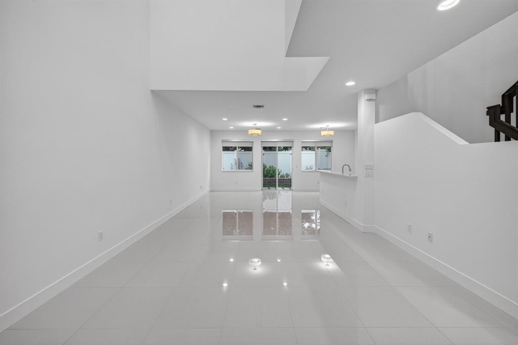 737 Southeast 1st Court, Unit 737 Pompano Beach, FL 33060 - Photo 17 of 53 a view of an empty room with kitchen and chandelier