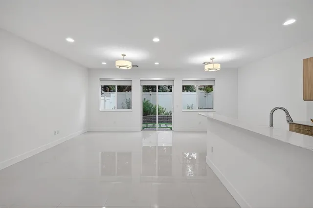 a large white kitchen with a large window and stainless steel appliances