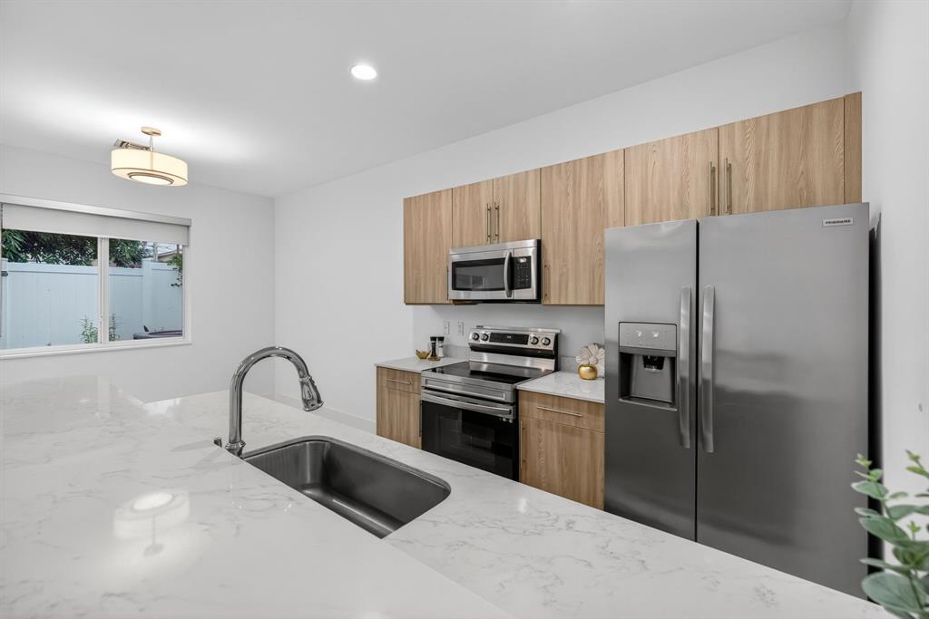 737 Southeast 1st Court, Unit 737 Pompano Beach, FL 33060 - Photo 6 of 53 a kitchen with a refrigerator sink and stainless steel appliances