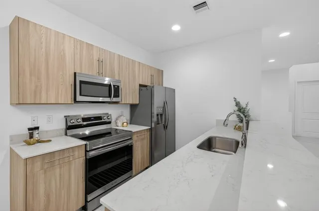 a kitchen with stainless steel appliances a refrigerator a stove a microwave and cabinets