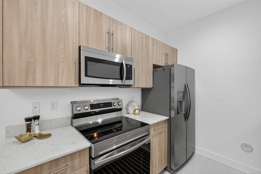 737 Southeast 1st Court, Unit 737 Pompano Beach, FL 33060 - Photo 8 of 53 a kitchen with stainless steel appliances a refrigerator a stove a microwave and cabinets