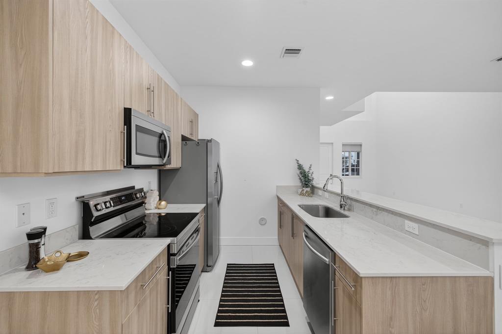 737 Southeast 1st Court, Unit 737 Pompano Beach, FL 33060 - Photo 9 of 53 a kitchen that has a sink and a stove