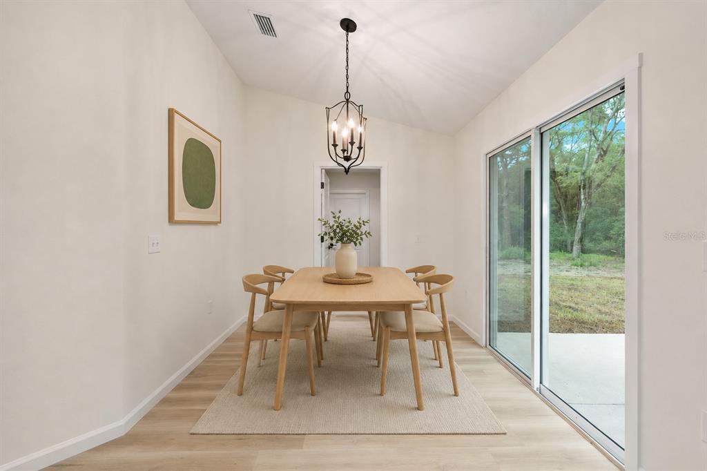 14769 Southwest 24th Place Ocala, FL 34481 - Photo 14 of 33 a dining room with chandelier and wooden floor
