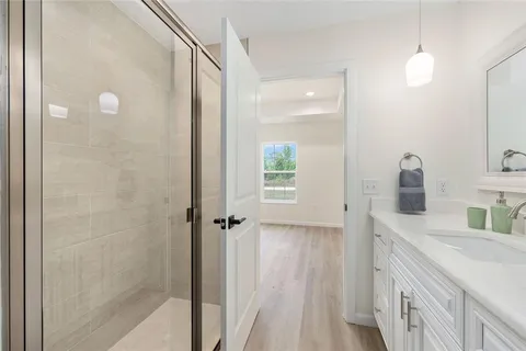a bathroom with a double vanity sink a mirror and a shower