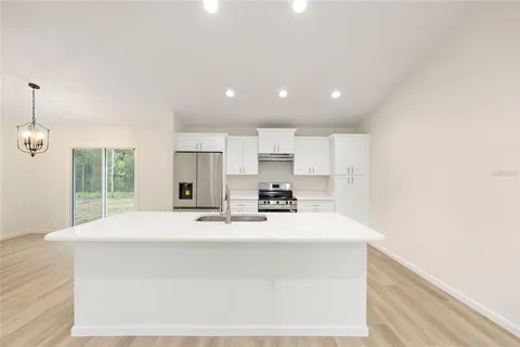 a kitchen with kitchen island sink stove and refrigerator