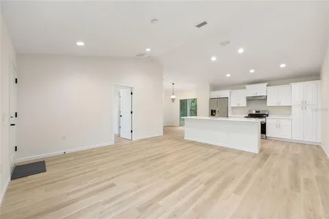 a view of kitchen with kitchen island white cabinets and wooden floor